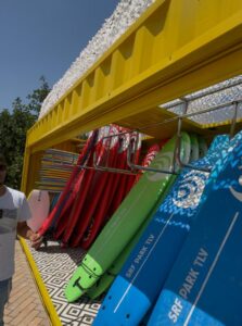 הסבת מכולות באורך 6 מטר למחסן ייעודי לגלשנים עבור בריכת גלים, כולל תריס חשמלי, שיפוץ מקיף ופתרון מותאם אישית לצורכי הלקוח.